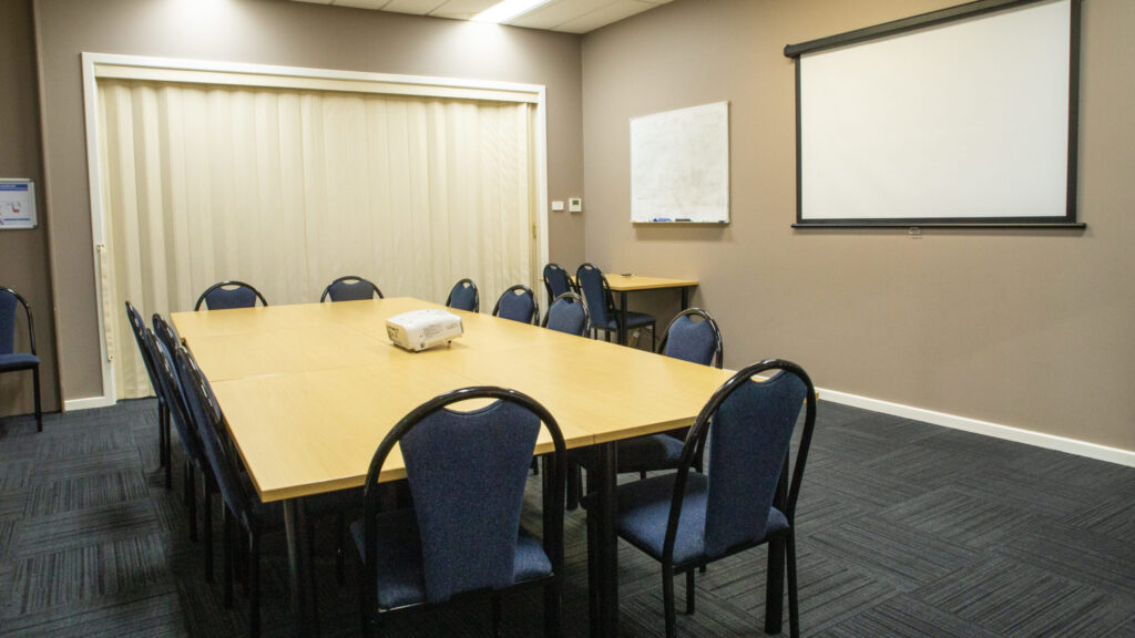 meeting room with whiteboard, table and chairs
