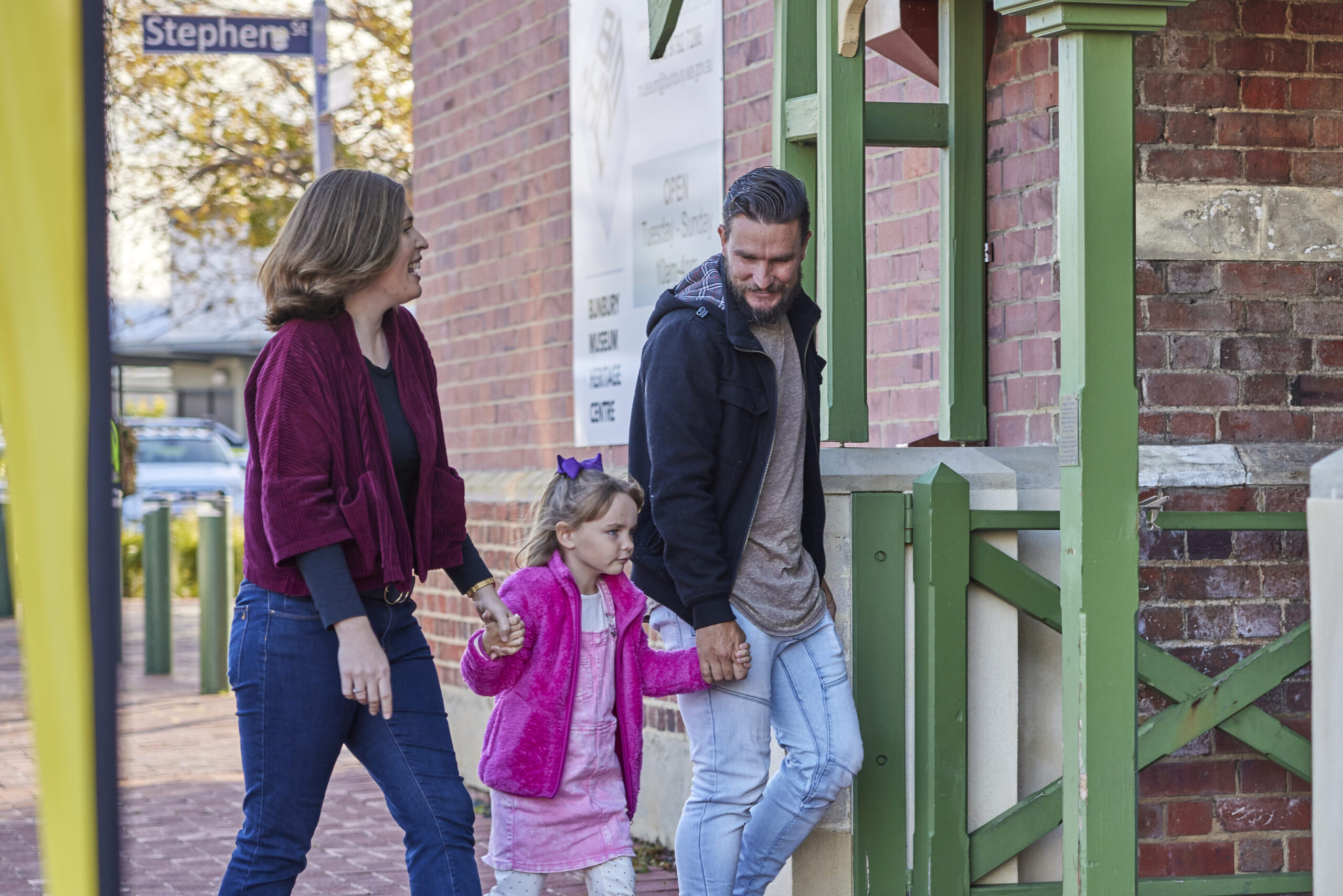 family of three walking through entry pillars to historic building