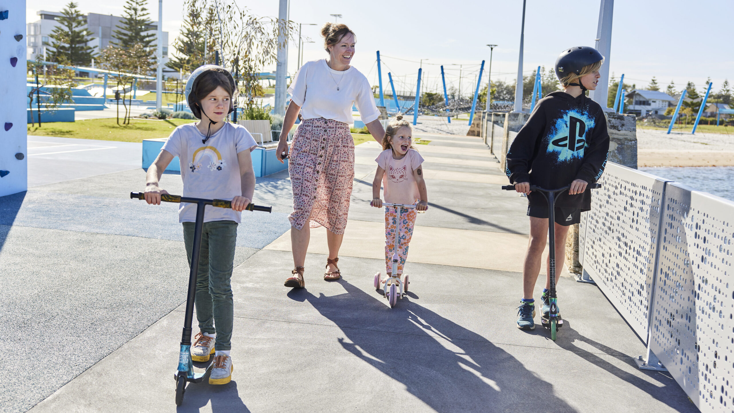 A mum pictured with her two sons and daughter on scooters at Koolambidi Woola.