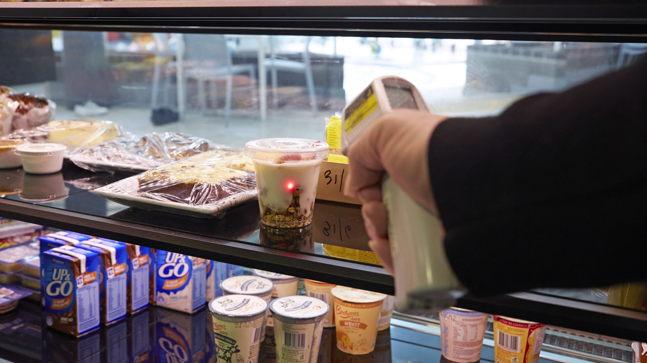 The temperature of food in a refrigerated display cabinet being checked with a handheld thermometer. 