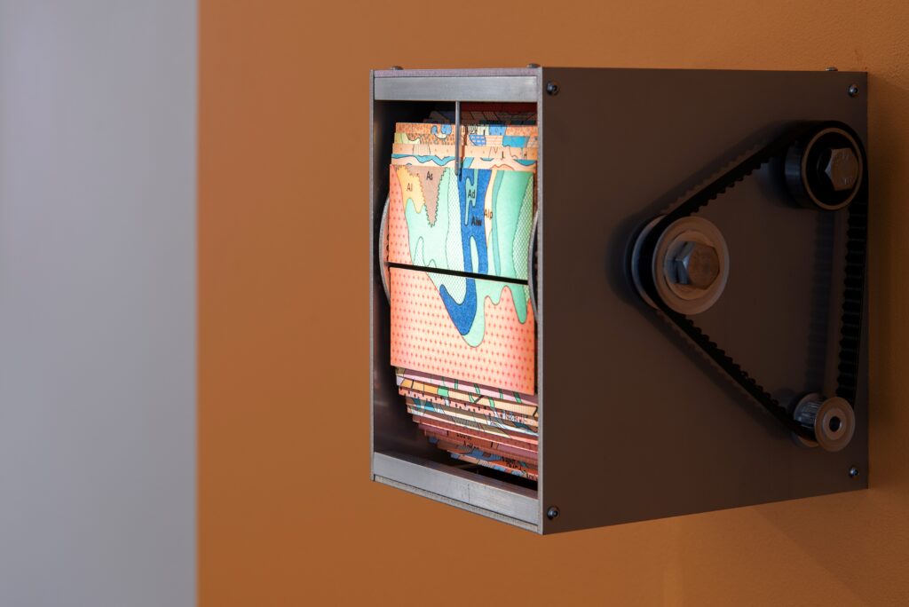 metal box with pulley mechanism fixed to wall, box contains picture cards