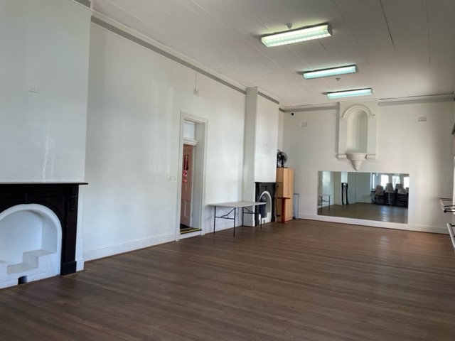 large empty room with timber floors and mirrors
