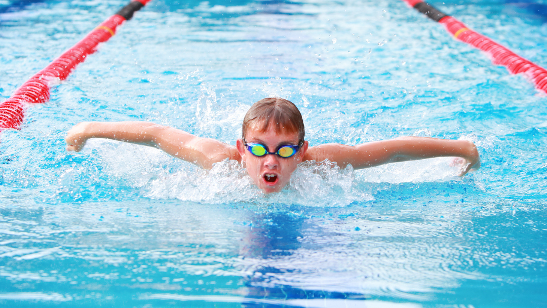 Child swimming butterfly in a lane